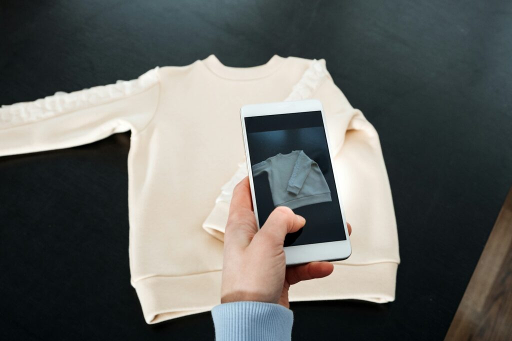 Sell Online on the Internet. Ecommerce store. Woman taking photo of clothes on smartphone. Selling